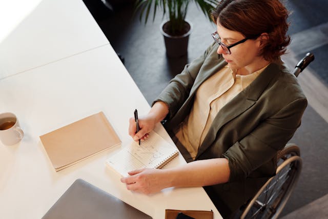 woman in wheelchair working at desk