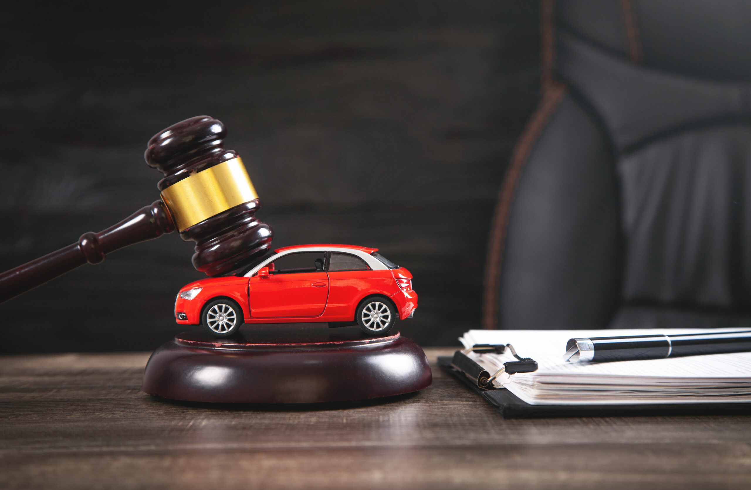 Judge gavel over car and document.
